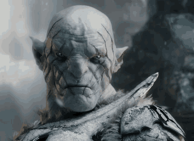 a close up of an orc holding a sword and looking at the camera