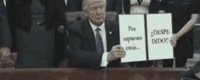a man is holding a sign that says por supuesto estas