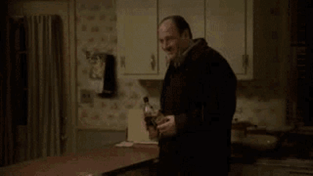 two men are standing in a kitchen talking to each other