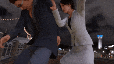 a woman in a white suit is fighting a man in a blue shirt