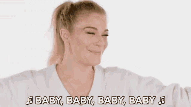 a woman in a white shirt is singing the song baby baby baby baby .