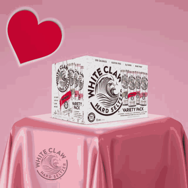 a box of white claw hard seltzer variety pack sits on a pink table cloth