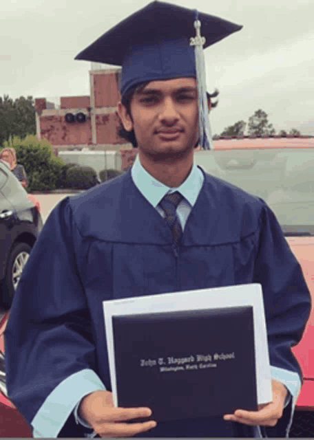 a man in a graduation cap and gown is holding a diploma
