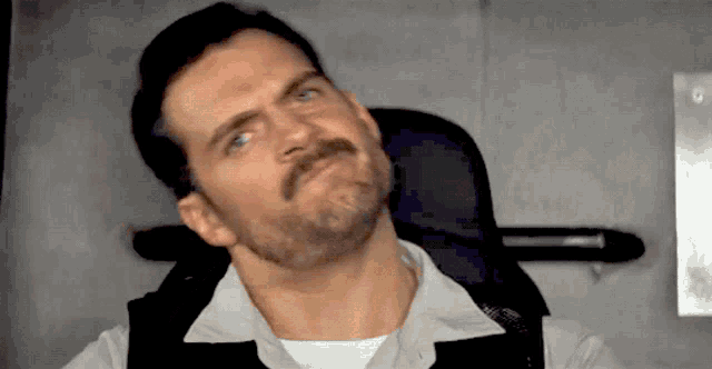 a man with a beard and mustache is looking up at something