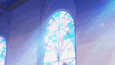 a stained glass window in a building with a blue light shining through it