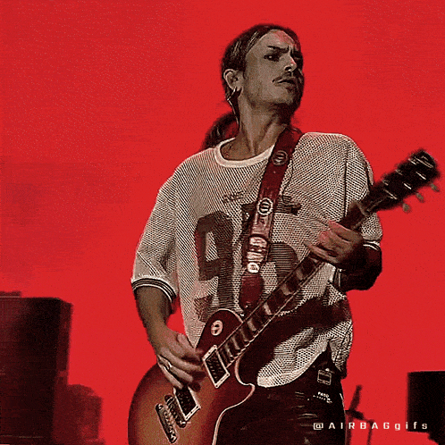 a man playing a guitar in front of a red background that says ' airbaggifs ' on it