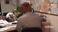 a man wearing a bear hat is sitting at a desk in front of a computer .