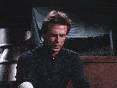 a man in a blue shirt is holding a large ostrich egg