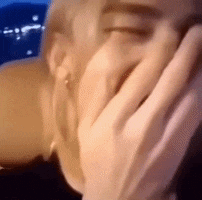 a close up of a person covering their mouth with their hands