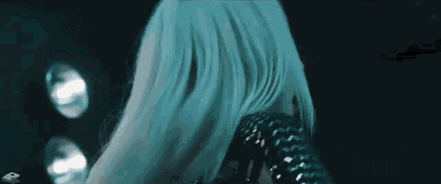 a close up of a woman 's hair in a dark room in a blue light .