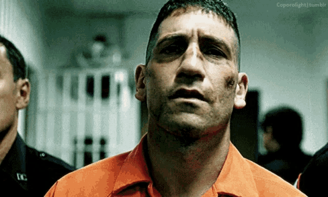 a close up of a man in an orange shirt