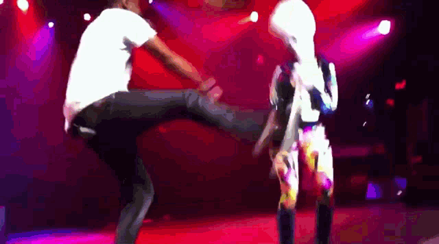 a man is kicking a woman on a stage