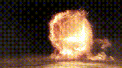 a large explosion with a lot of flames coming out of it in the dark .