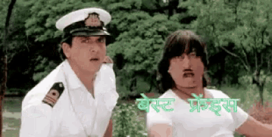 two men in military uniforms are standing next to each other in front of trees ..