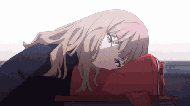 a girl with blonde hair and blue eyes is laying on a red backpack