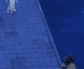 a man in a cape stands on a brick sidewalk next to a body of water