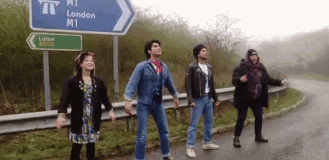 a group of people are dancing in front of a london m1 sign