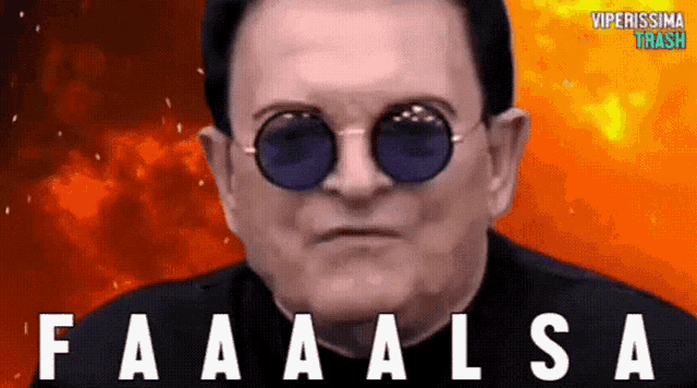 a man wearing sunglasses says faaaalsa in front of a fire background