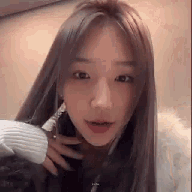 a close up of a woman with long hair wearing a white sweater .