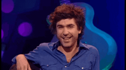 a man in a blue shirt with the words it 's james lance behind him