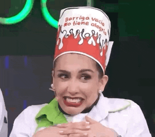 a woman wearing a chef 's hat is making a funny face and smiling .