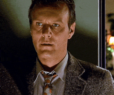 a man wearing a suit and tie is looking at the camera