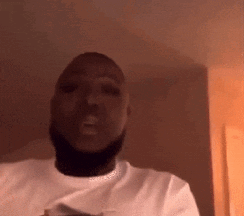 a man with a beard is wearing a white t-shirt .
