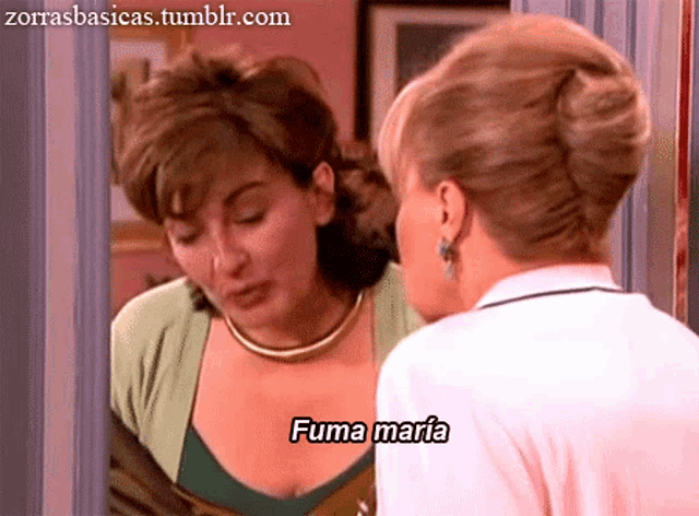 a woman looks at her reflection in a mirror and says fuma maria in spanish