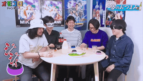 a group of men are sitting around a table and one of them is wearing a purple xlarge shirt