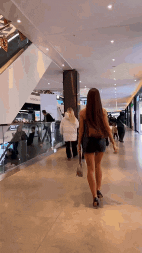 a woman is walking in a mall with a sign that says ' nokia ' on it