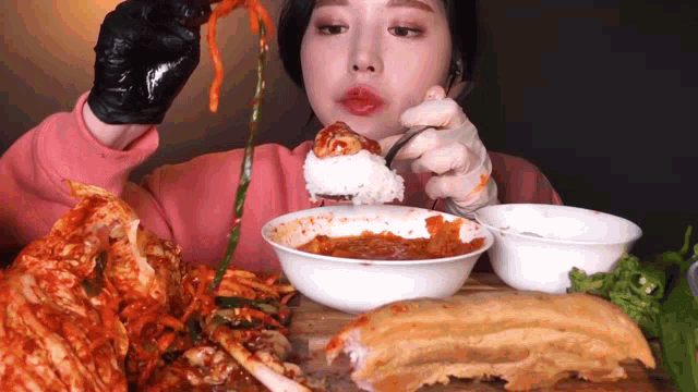 a woman is eating a bowl of food with a fork and spoon .