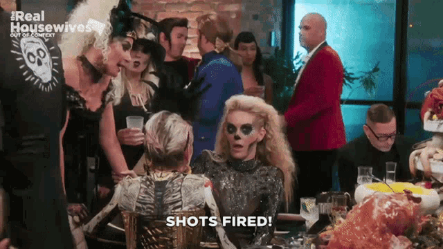 a woman in a skeleton costume says shots fired in front of a crowd of people