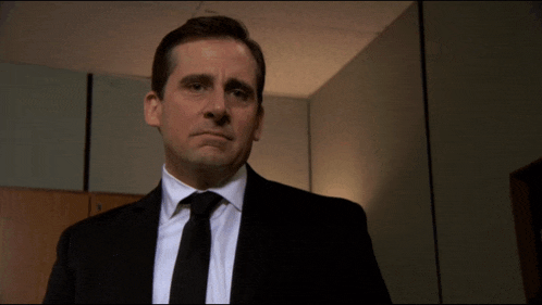 a man in a suit and tie is standing in a dark room