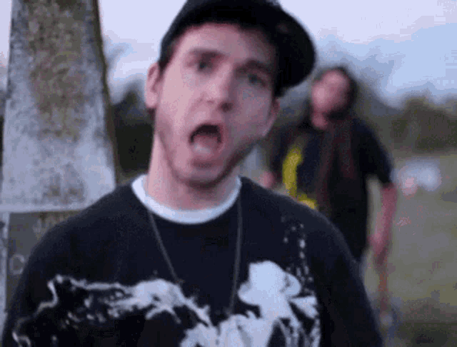 a man wearing a black shirt with a skull on it is making a funny face