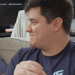 a man wearing a blue shirt with the letter f on it is sitting on a couch .
