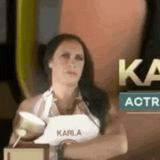 a woman in a white apron is holding a trophy in her hand .