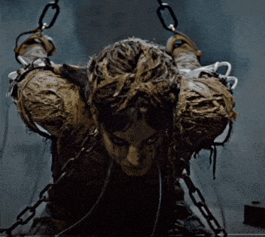 a mummy with chains around his neck and arms is looking at the camera