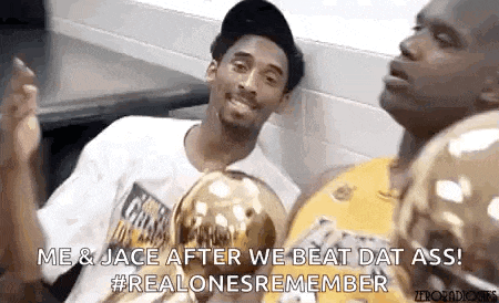 kobe bryant and shaquille o'neal are sitting next to each other in a locker room with trophies .