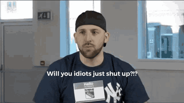 a man wearing a ny yankees shirt says " will you idiots just shut up ?? "