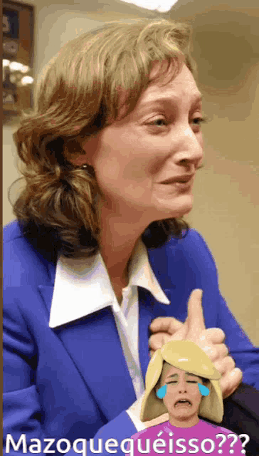 a woman in a blue suit is holding a picture of a woman with tears in her eyes