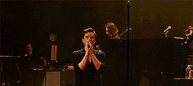 a man is holding a microphone and clapping his hands