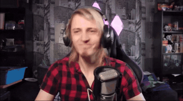 a man wearing headphones is making a funny face in front of a microphone