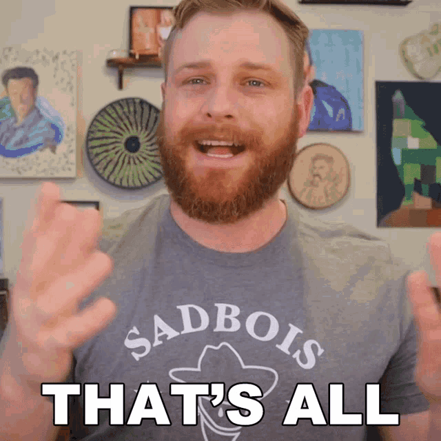 a man with a beard is wearing a sadbois shirt