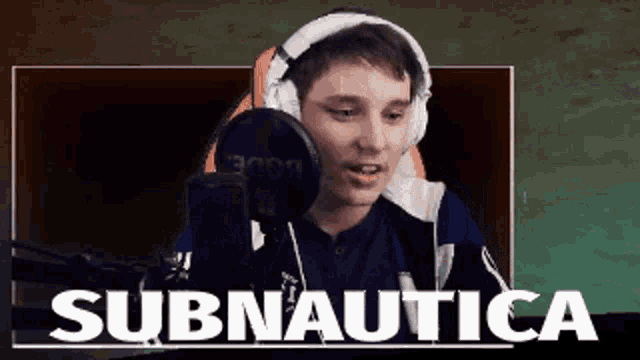 a man wearing headphones is talking into a microphone and the words subnautica are behind him