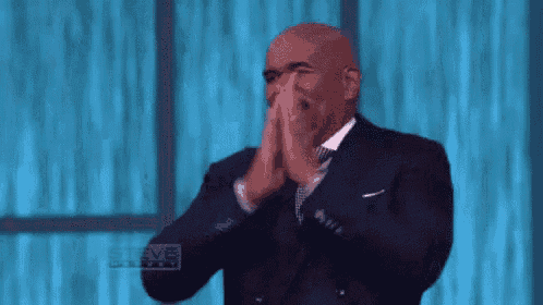 a bald man in a suit and tie is applauding .