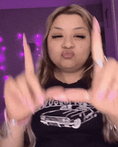 a woman wearing a black shirt with a car on it making a funny face