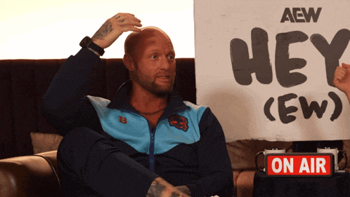 a man holding a sign that says hey ew