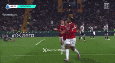 a group of soccer players are celebrating a goal on a soccer field