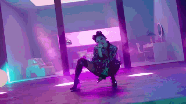 a woman is kneeling down in a room with purple lights .