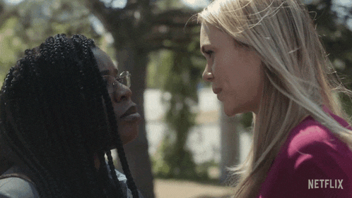 two women looking at each other with a netflix logo on the bottom right